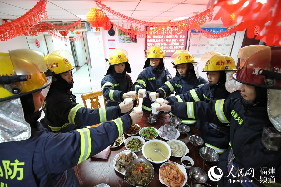 漳州消防特勤大隊一中隊消防指戰(zhàn)員歡聚一堂，吃年夜飯，舉杯共飲。