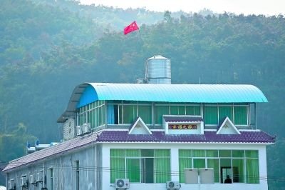 左圖:那邦鎮(zhèn)一居民樓上矗立著中國國旗 特派記者 賈代騰飛 攝