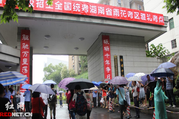 高考學(xué)子冒雨進(jìn)入考場(chǎng)。