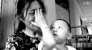 視頻中“小中寶”看到奶奶為他掉眼淚，就伸手為奶奶抹去眼淚。視頻截圖 