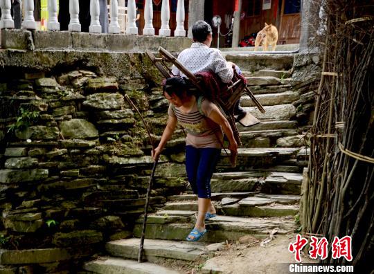 圖為趙先瓊背著婆婆出村就醫(yī)（資料圖）。